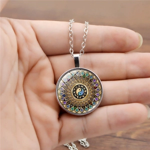 Gros plan du pendentif mandala zodiaque avec motif yin yang et chaîne en argent vintage