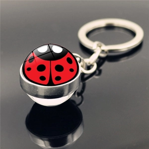 Macro shot of 45-degree angle ladybug glass ball keychain with silver metal base