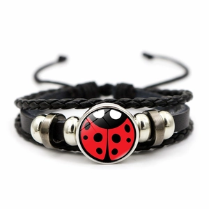 Macro shot of multi-layer leather bracelet with ladybug pattern glass charm