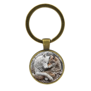 Bronze wolf glass dome keychain featuring two wolves with artistic floral background