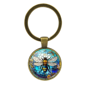 Vintage bronze bee keychain with stained glass style bee pattern on honeycomb background