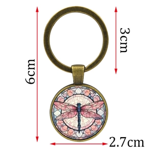 Vintage bronze dragonfly keychain with stained glass style circular pendant on white background