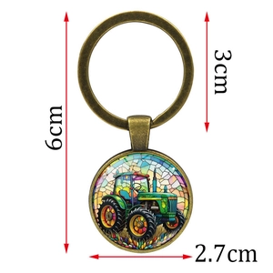 Vintage green tractor keychain with bronze metal ring and dimensions marked on white background