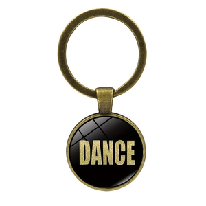 Dettaglio portachiavi in bronzo con logo DANCE nero e glitter dorati scintillanti