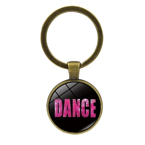 Dettaglio portachiavi in metallo bronzo con scritta Dance glitterata rosa su nero