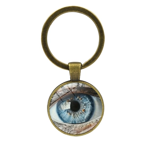 Porte-clés en bronze avec un pendentif cabochon œil bleu réaliste sur fond blanc