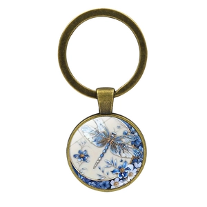 Vintage bronze dragonfly keychain with blue floral glass pendant on white background
