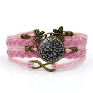 Macro shot of pink braided layered bracelet with vintage Viking compass and infinity charm