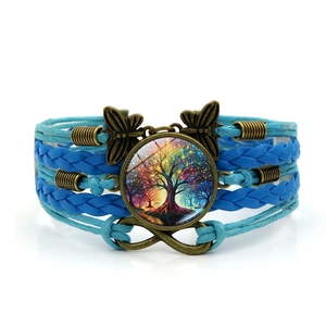 Détail d'un bracelet multi-rangs en cuir bleu avec l'arbre de vie et signe infini