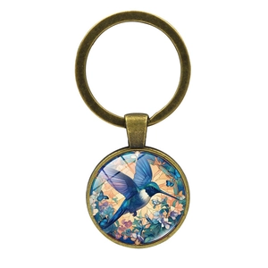 Vintage bronze hummingbird glass cabochon keychain with floral artwork on white background