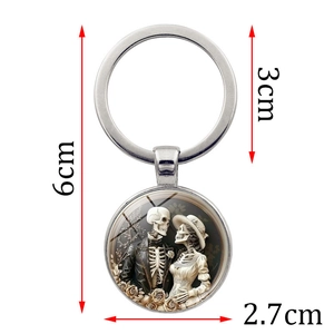 Vintage gothic skull couple glass dome keychain with polished silver metal finish