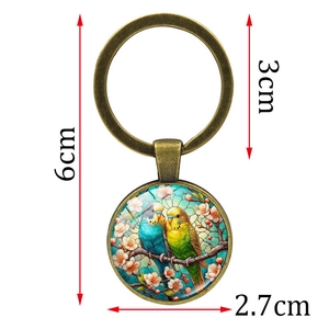 Bronze keychain with round glass pendant featuring two parrots on a cherry branch