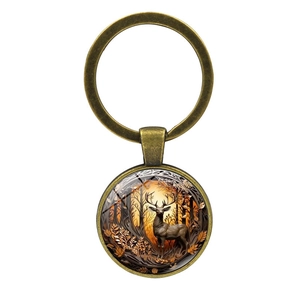 Detailed macro of vintage bronze elk keychain with artistic forest design on glass cabochon