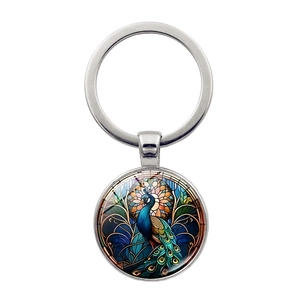 Detailed view of colorful peacock keychain with vibrant glass art style and silver metal frame