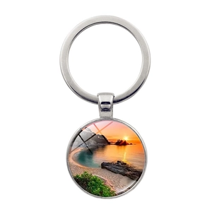 Gros plan détaillé d'un porte-clés en métal argenté avec pendentif paysage de coucher de soleil