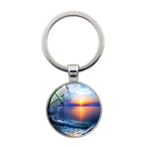 Gros plan d'un porte-clés coucher de soleil sur la plage avec anneau en métal poli et dôme