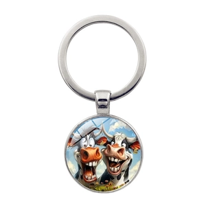 Close-up of funny cartoon cow glass cabochon pendant with silver metal keyring