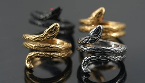 Dettaglio degli anelli a serpente avvolti in oro, argento e nero con occhi di rubino