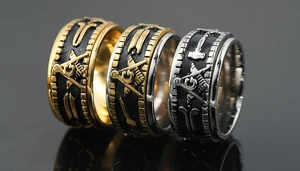 Close-up of three Freemason spinning rings in gold and silver with relief G symbols