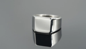 Macro di un anello a sigillo quadrato in acciaio inossidabile lucido effetto specchio