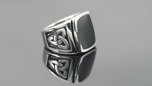 Makroaufnahme eines Vintage-Rings aus Titanstahl mit schwarzer Einlage und keltischen Knoten