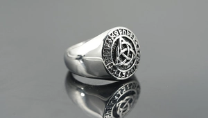 Macro detail of rotating stainless steel ring with Celtic knot and Nordic runes