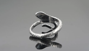 Macro shot of silver snake ring with scale texture and S925 engraving on black mirror