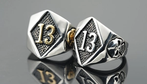Macro shot of two vintage punk style rings with number 13 detail and hexagon shield design
