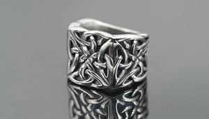 Vue macro d'une bague rétro en acier inoxydable avec texture de nœud celtique tissée