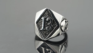 Macro view of vintage style steel ring featuring number 13 and skull side engraving