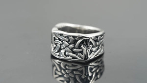 Vue macro d'une large bague en acier inoxydable avec des motifs de nœuds vikings