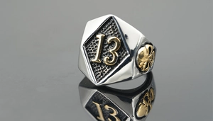 Macro view of vintage titanium steel skull ring with embossed golden number 13