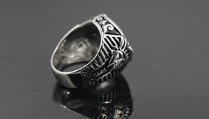 Macro detail of retro stainless steel ring featuring an Egyptian Pharaoh mask engraving