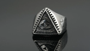 Macro shot of silver titanium steel ring with Eye of Providence engraving and vintage texture