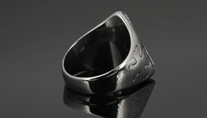 Macro shot of silver titanium steel viking ring showing side cross carvings and thick metal