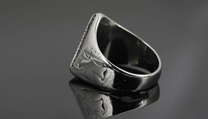 Macro detail of men's titanium steel ring with embossed cross and textured rim