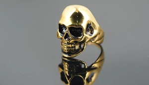 Detailed top view of gold punk skull ring with polished finish and black vintage accents