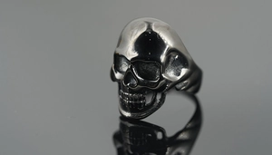 Macro shot of punk style skull ring with detailed metallic texture and polished silver finish