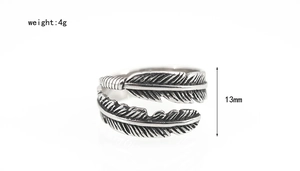 Detailed macro view of the vintage feather texture on a 13mm wide stainless steel ring