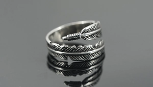 Macro shot of silver feather ring with detailed vintage textures and adjustable open band