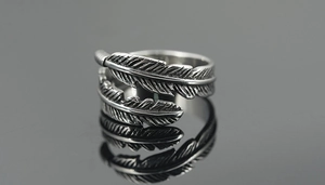 Macro detail of retro feather titanium steel ring with intricate vintage oxidation textures