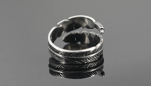 Detailed close-up of retro silver feather ring with intricate textures and adjustable band