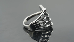 Detailed macro view of silver titanium steel ring featuring a gothic skull hand design
