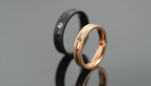 Macro detail of matte titanium steel rings with central groove and small zircon inlay