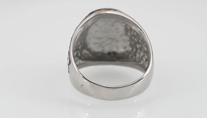 Détail d'une bague large en acier titane argenté avec texture martelée et reliefs
