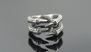 Macro detail of punk dragon claw ring showing intricate scale textures and polished tips