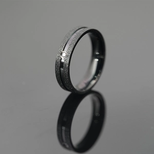 Matte black titanium steel ring for couples featuring a polished groove and center crystal