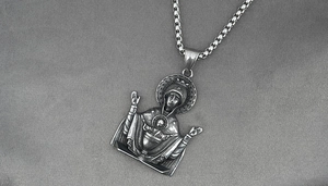 Macro detail of retro Virgin Mary pendant with vintage relief on a square box chain