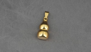 Top view of polished golden gourd pendant with metallic mirror finish on fabric