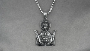 Macro shot of Virgin Mary relief pendant on vintage stainless steel box chain